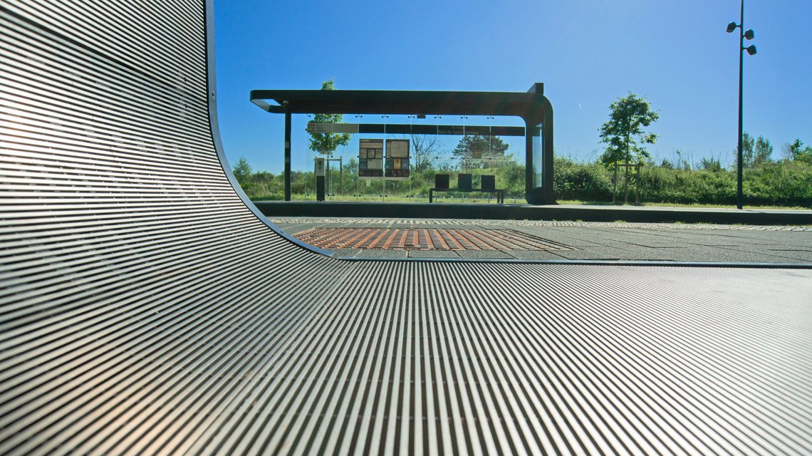 Platelage slot cintré – Continuité architecturale Tram 12 - <p>Platelage métallique en slot inox 316L cintré assurant une continuité esthétique entre habillage vertical et sol technique. Solution sur mesure pour aménagement urbain et transport public.</p>